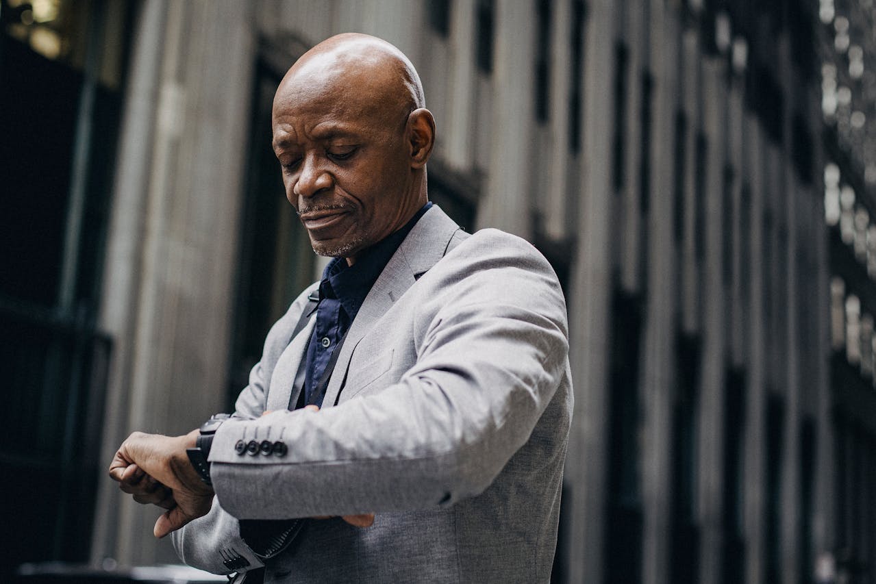 businessman looking at watch in city